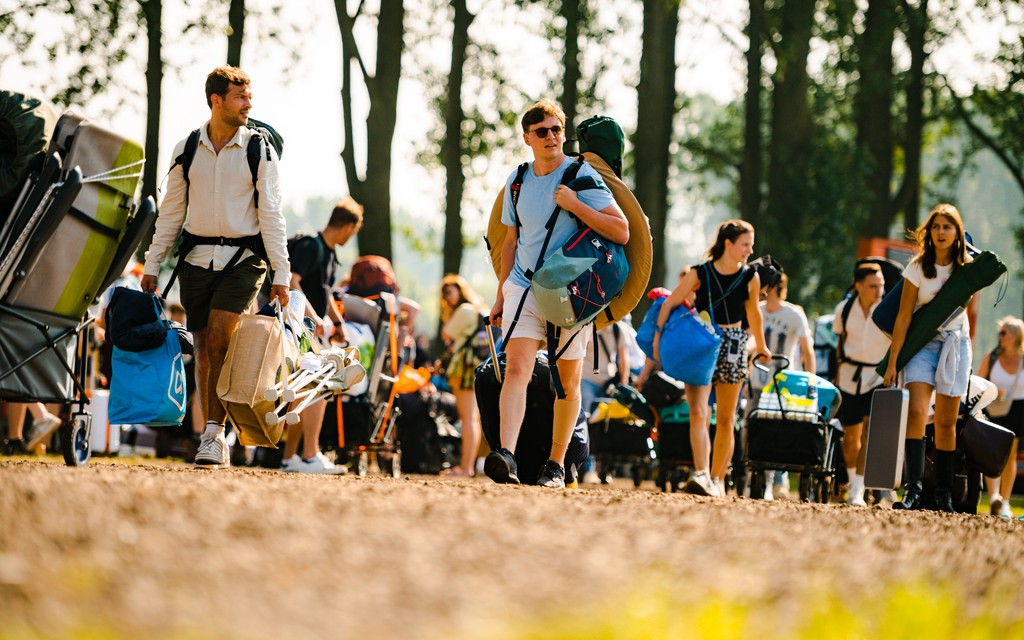 Bezoekers zijn met bolderkar onderweg naar de polsbandjestent Bezoekers zijn met bolderkar onderweg naar de polsbandjestent