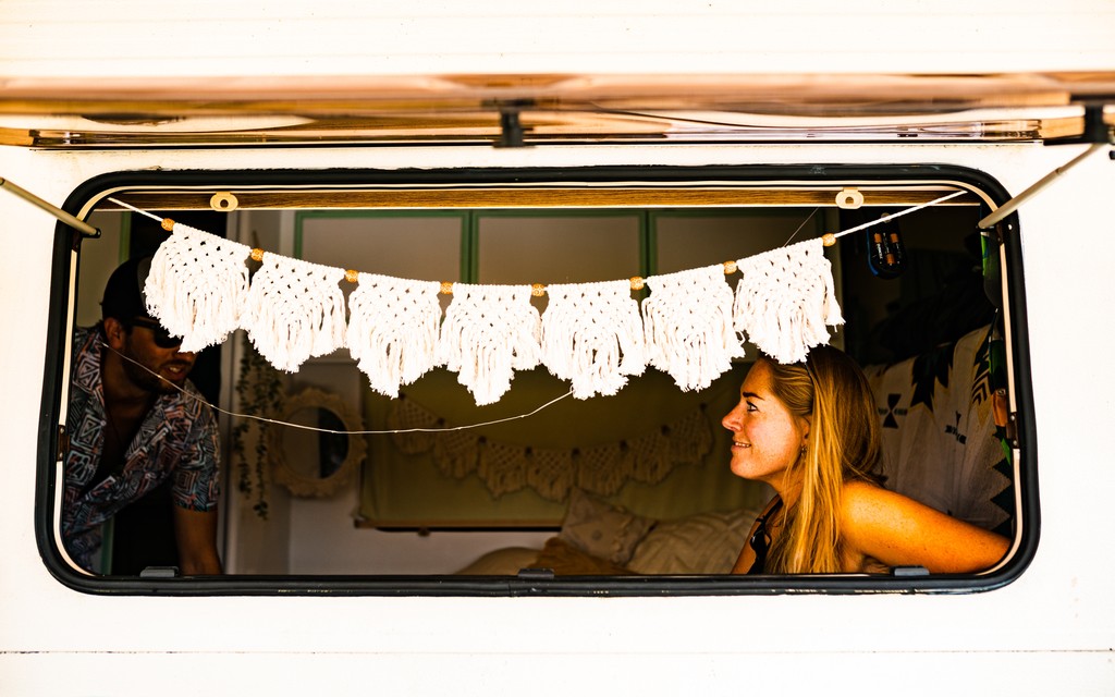2 bezoekers zitten achter het raam in hun caravan 2 bezoekers zitten achter het raam in hun caravan