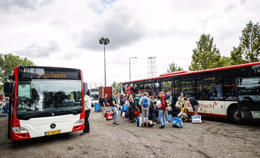 Groep bezoekers verlaat een pendelbus Groep bezoekers verlaat een pendelbus